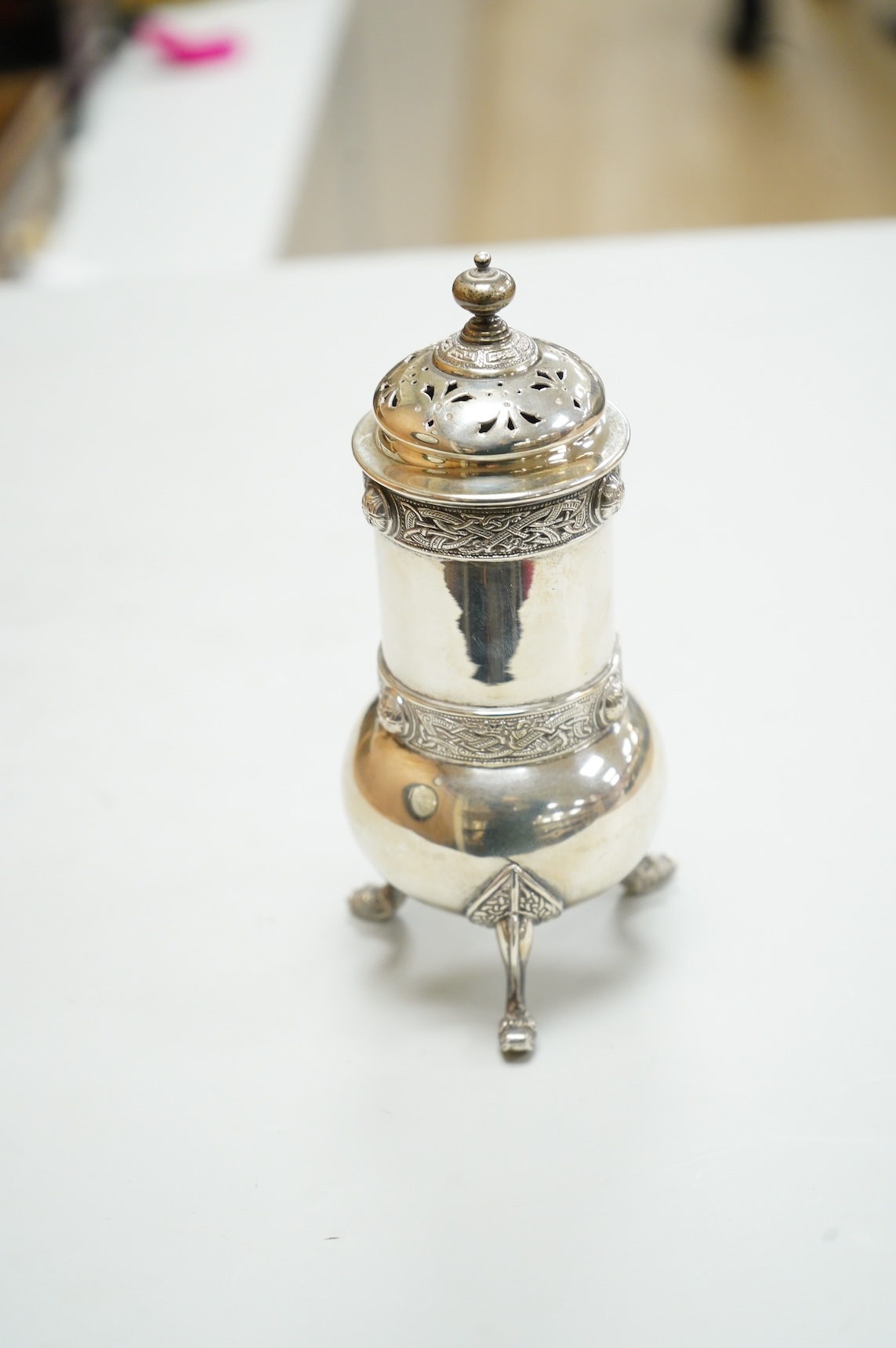 A George V Irish silver sugar caster, by West & Son, Dublin, 1914, decorated with Celtic bands, height 16.7cm, 9.9oz.